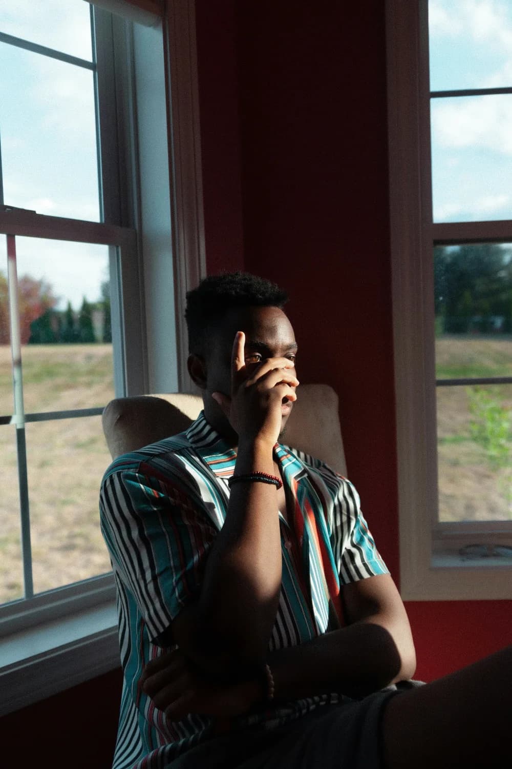 A person sitting beside a sunlit window