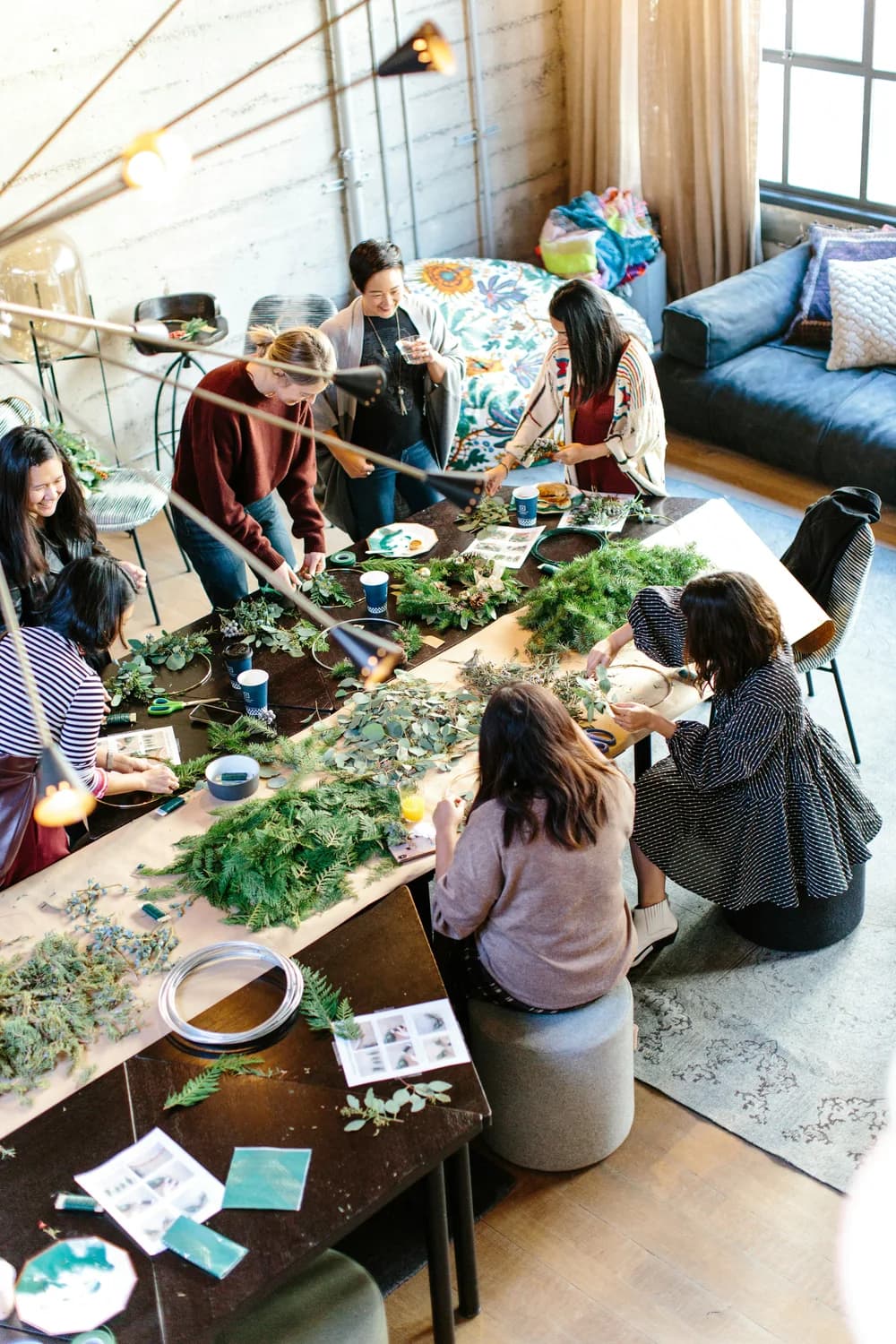 People making wreaths together around a shared table