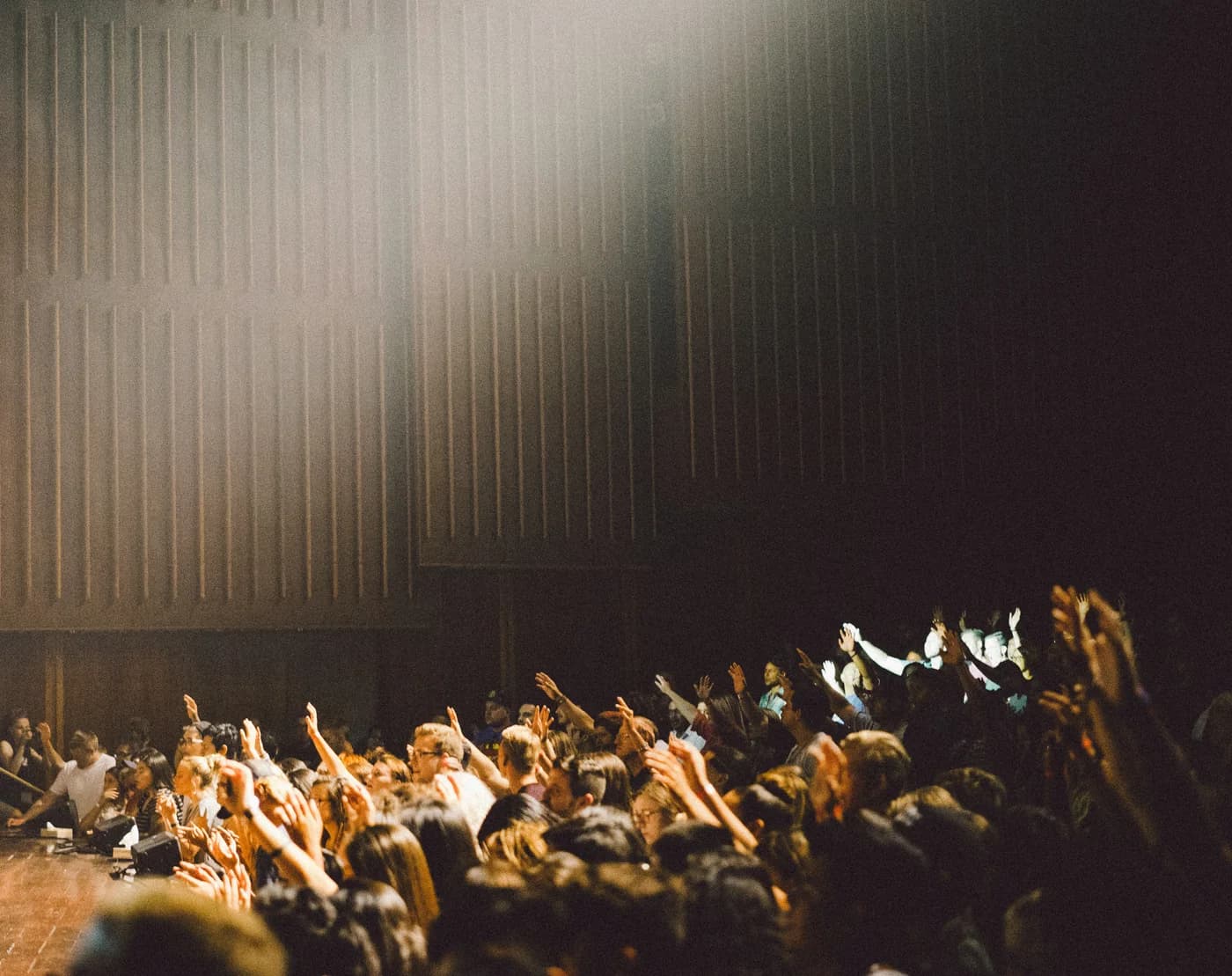An audience raising their hands during an event
